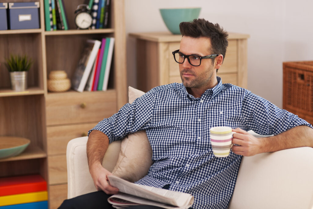 Portrait of focus man with newspaper and cup of coffee