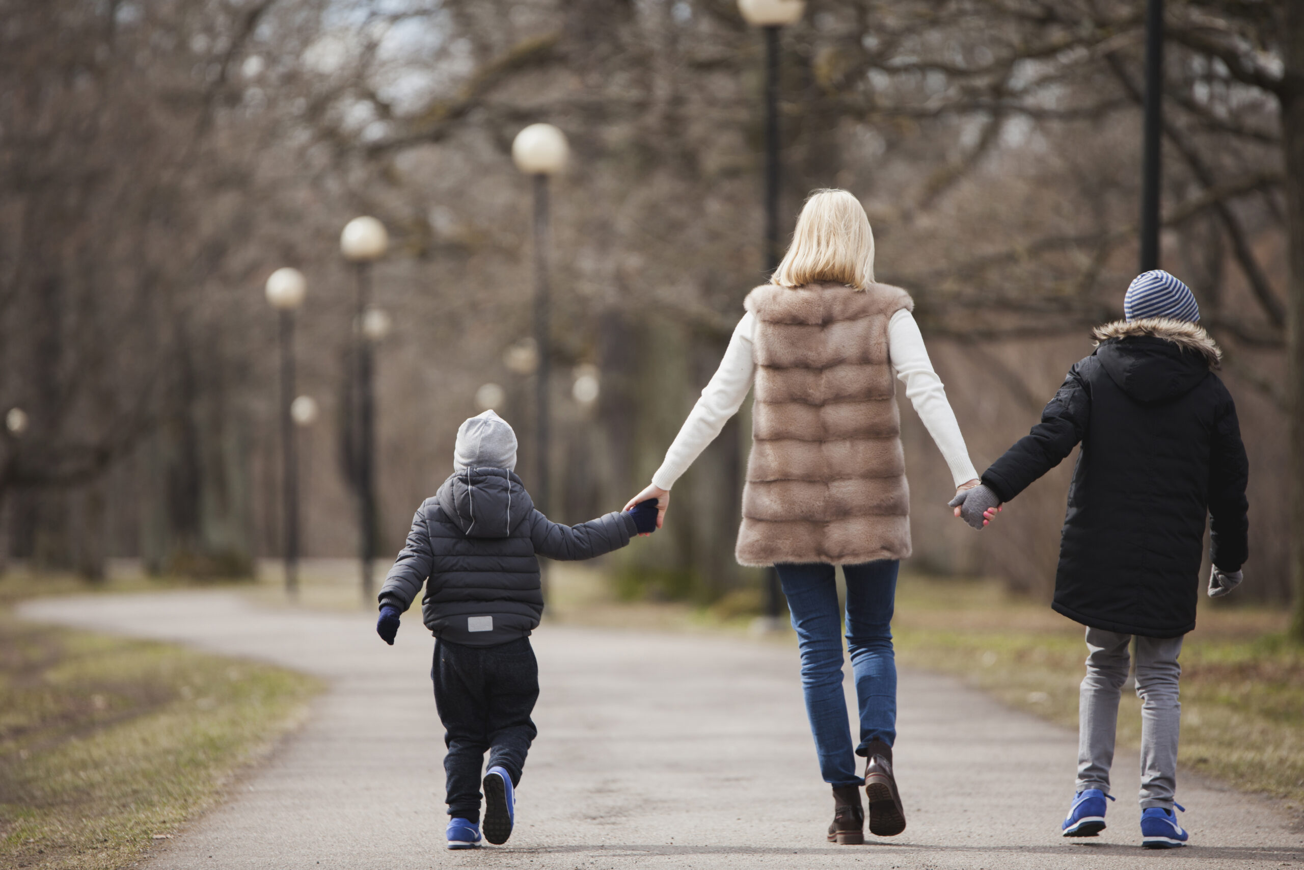 rear-view-mother-children-walking
